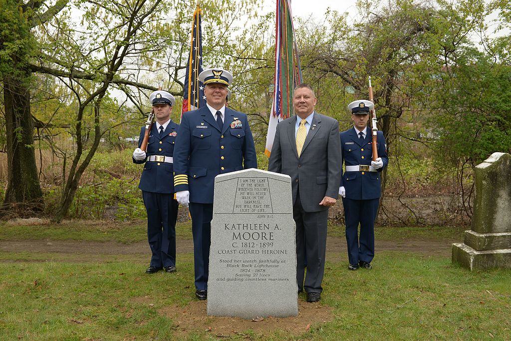 Captain Ed Cubanski, commander of Coast Guard Sector Long Island Sound, left, and Charles “Skip” Bowen, vice president of government relations at Bollinger Shipyards and former master chief petty officer of the Coast Guard, along with members from Coast Guard Sector Long Island Sound’s Color Guard, stand behind a grave marker dedicated to former Lighthouse Keeper Kathleen Moore at the Mountain Grove Cemetery in Bridgeport, Conn., May 8, 2014. Moore was a lighthouse keeper of the Black Rock Harbor Lighthouse on Fayerweather Island, Conn., and is credited with saving 21 lives during her 61 years of service. (U.S. Coast Guard photo by PA2 Jetta H. Disco)